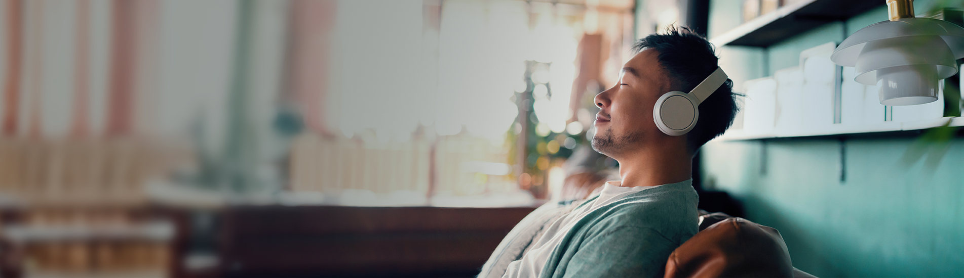 young man with headphones on relaxing on his sofa